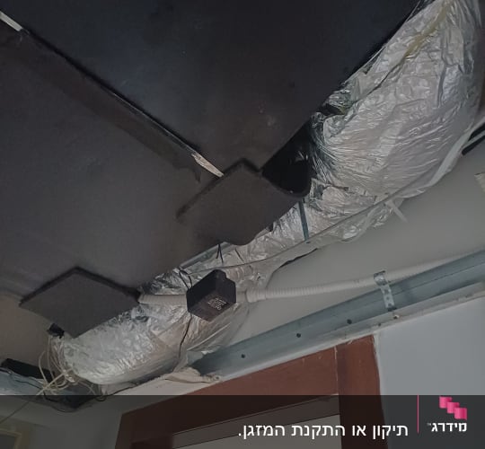 תעלות מיזוג אוויר בתקרה עם צינורות וחיבורים